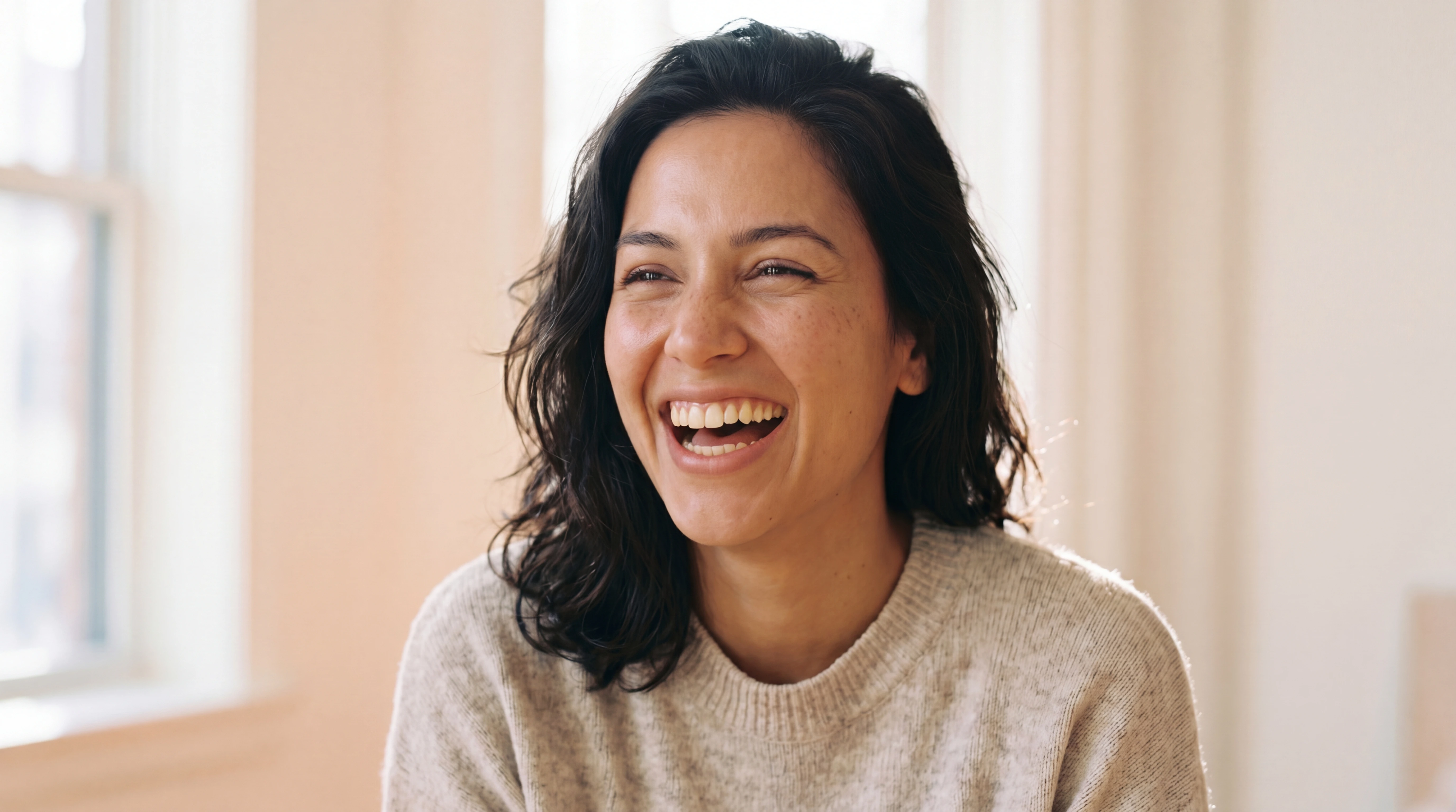 A young woman laughing joyfully with a confident natural smile — Smila dentist-supervised clear aligner result