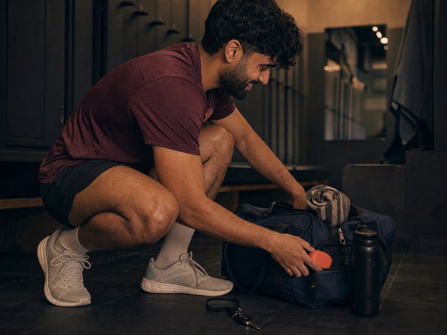 Un hombre británico de origen pakistaní guarda un estuche coral para alineadores en su bolsa de deporte después de entrenar, en un vestuario.